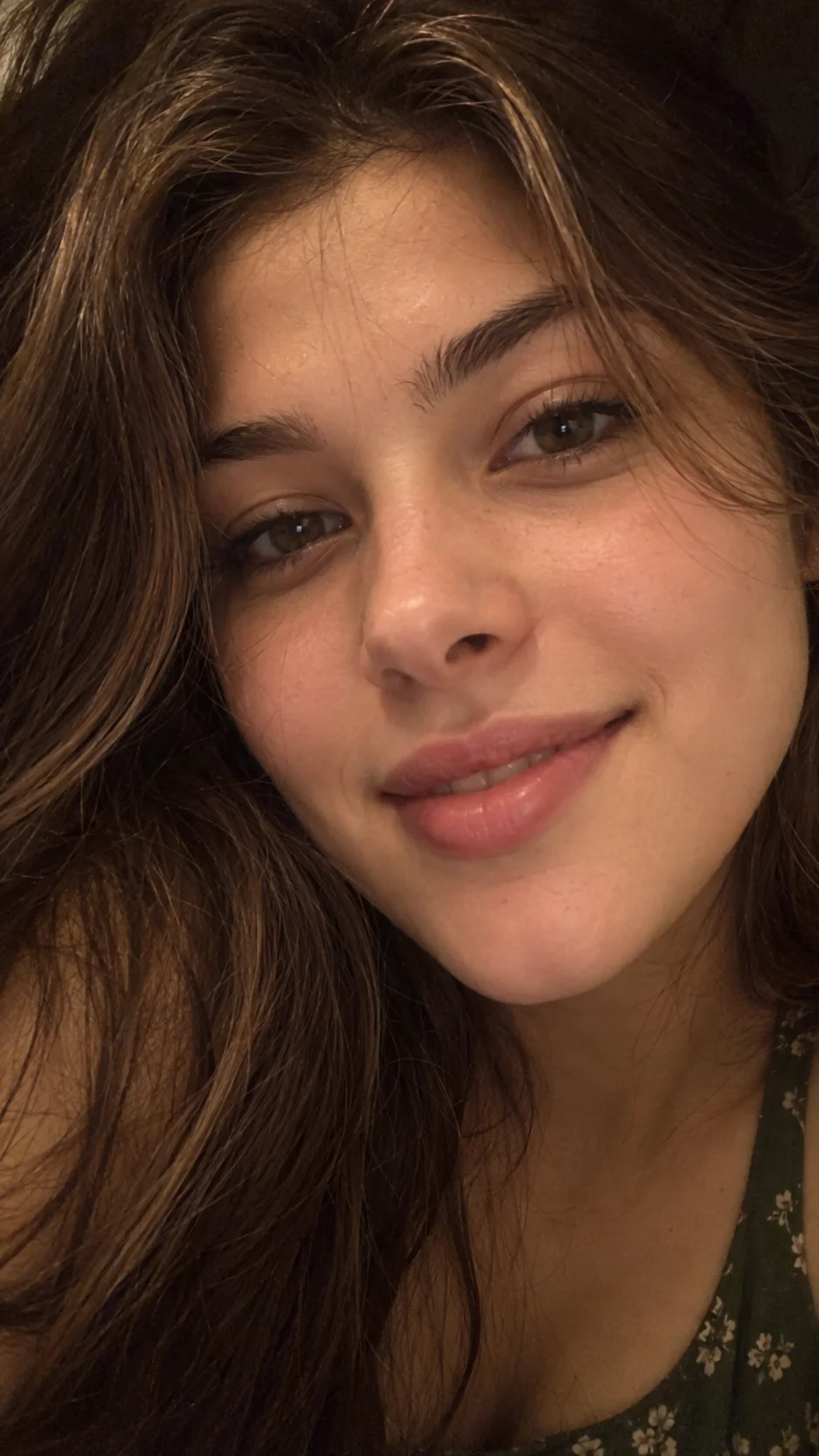Ultra-realistic extreme close-up front-camera selfie of a young adult woman, matching the reference image's exact framing, facial expression, and intimate distance from the camera.

**Camera distance and framing:** The smartphone camera is extremely close to her face, approximately 10–15 cm away, cr